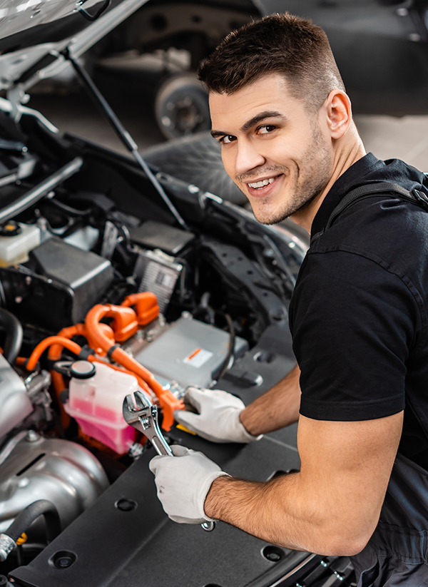 Mechanic holding a wrench while smiling to fix the car